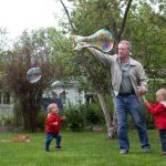 papà che gioca con i figli in giardino